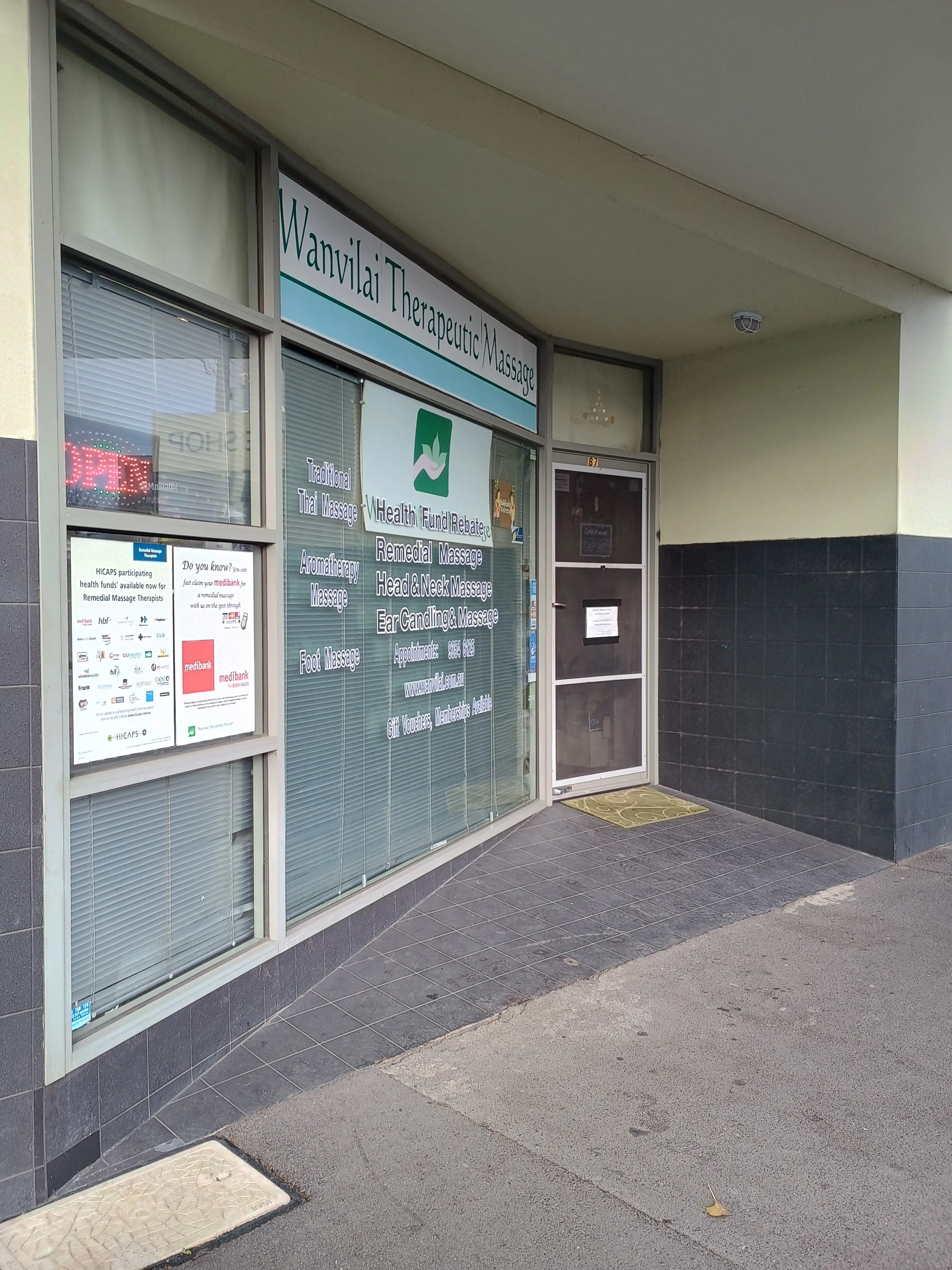 Shopfront at 87 Gaffney Street, Coburg — green-leaf fascia, services list on window, glass door numbered 87